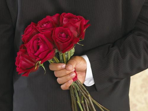 Праздники Открытка к 8 марта. Мужчина держит букет роз за спиной смайлы